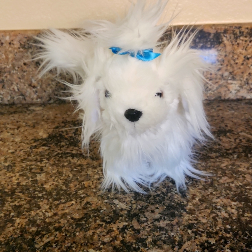 The stuffed animal is super cute with blue bow